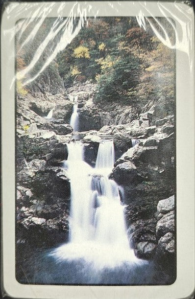 Waterfall in a forest with a vintage, torn paper effect