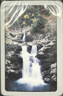 Waterfall in a forest with a vintage, torn paper effect