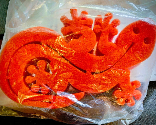 Red dragon-shaped decorations in clear plastic packaging on a gray surface.