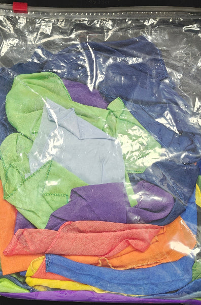 Colorful plastic bags in a clear package on a wooden surface.