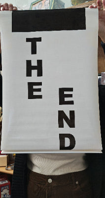 Text 'THE END' on a white background held by two hands.