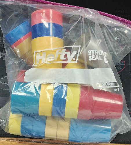 Colorful rolls of tape inside a clear plastic bag with 'Hefty' branding.
