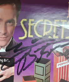 Product packaging with colorful design and text, featuring a person's face and various items.