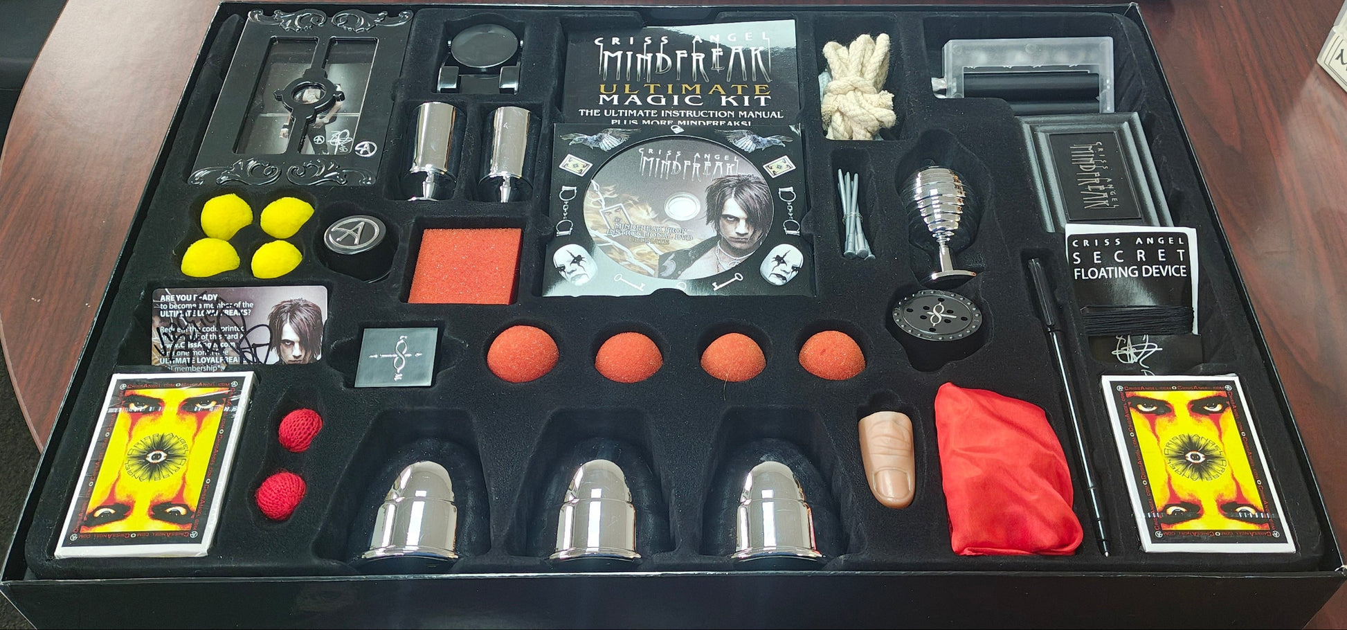 Collection of items including cards, tools, and a box on a wooden surface