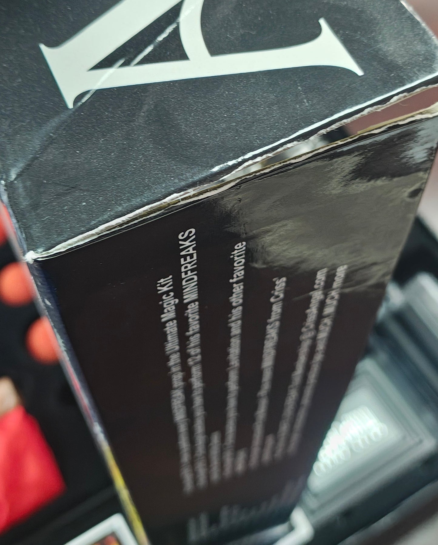 Close-up of a person holding a black box with visible branding.
