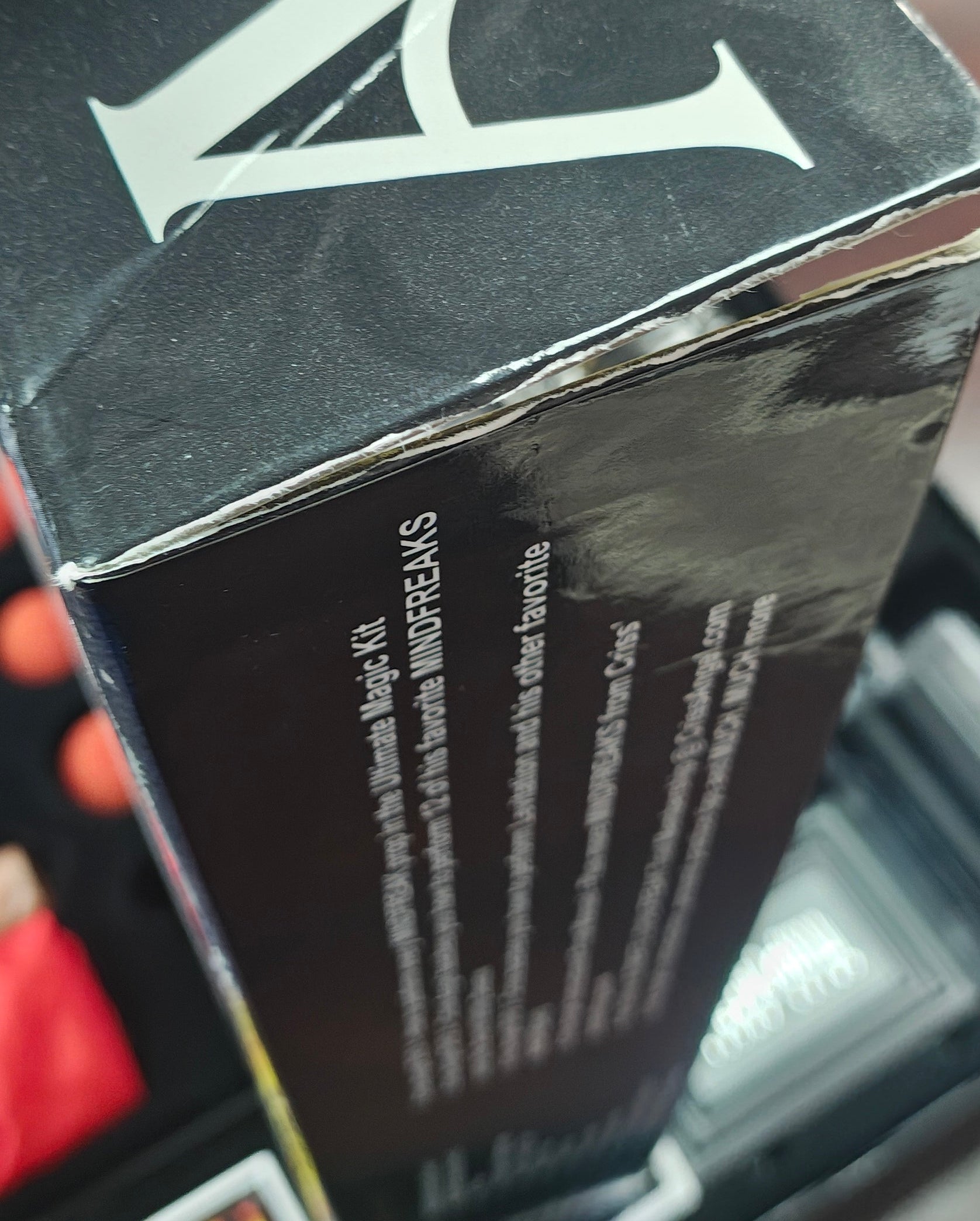 Close-up of a person holding a black box with visible branding.