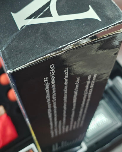 Close-up of a person holding a black box with visible branding.