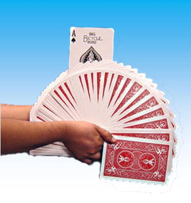 Hand holding a deck of red playing cards against a blue background
