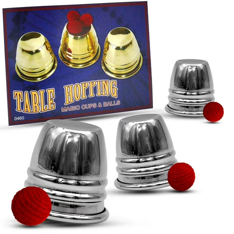 Magic cups and balls set with metallic cups and red balls, including a branded card.