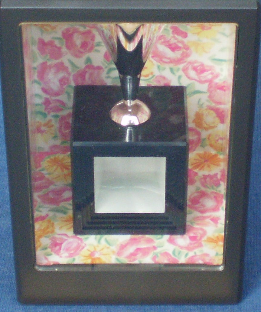 Black perfume bottle with a floral patterned box on a blue background