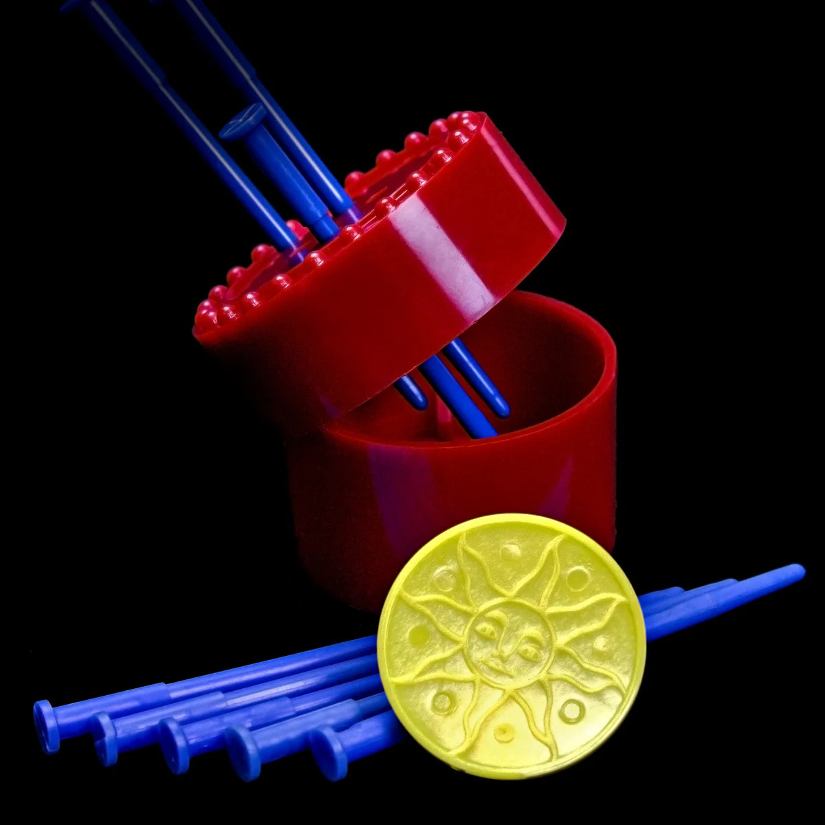 Red container with blue straws and a yellow lid on a black background