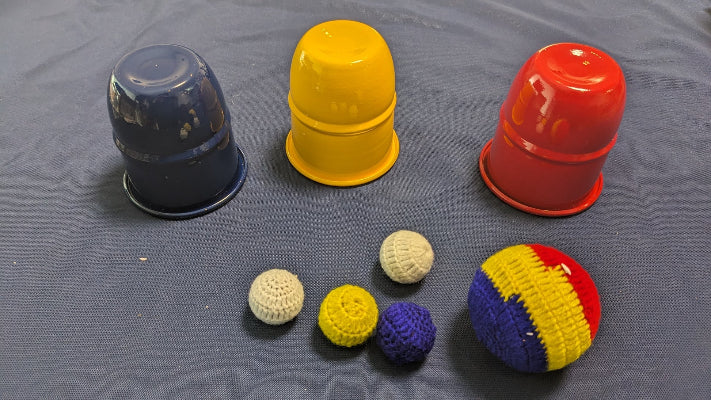 Colorful plastic cups and balls on a gray surface