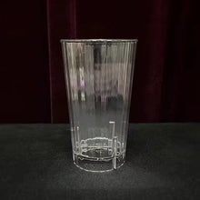 Clear glass tumbler with engraved design on a dark background