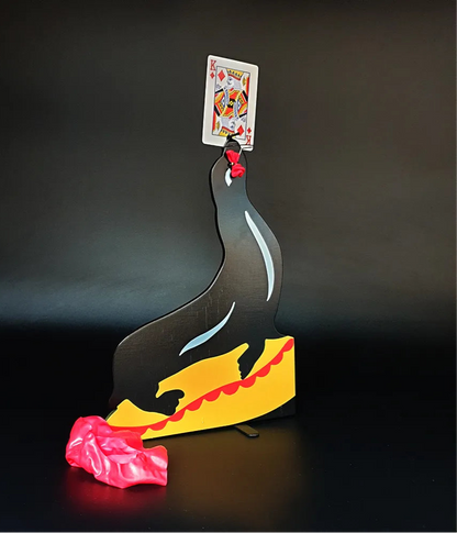 Decorative sculpture of a duck with a card on its head against a dark background
