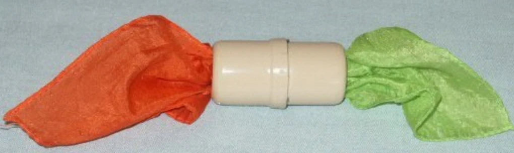Beige cylindrical object with orange and green cloths on a gray background