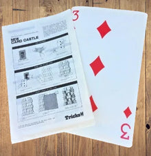 Playing cards with red diamond suits on a wooden surface