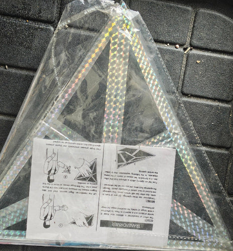 Holographic triangle object with instructions on a textured surface