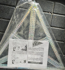 Holographic triangle object with instructions on a textured surface
