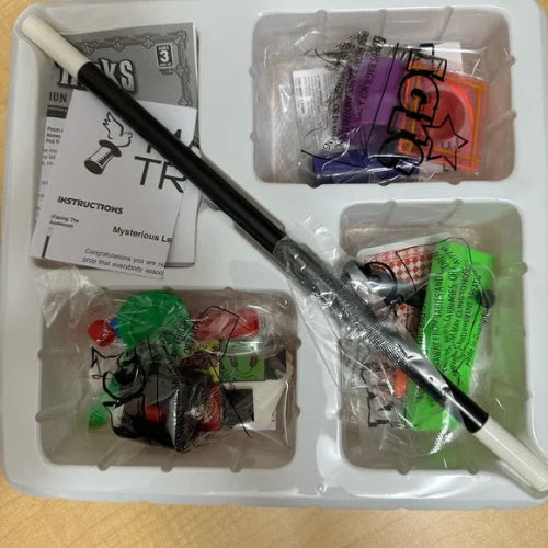 Hobby kit with tools and components in a clear plastic box on a wooden surface