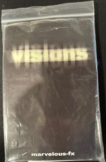 Black product with 'visions' and 'marvelous-fx' text in a clear plastic bag on a black background