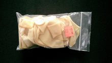 Packaged sliced white mushrooms with a label on a black background
