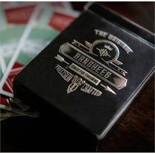 Black book with 'The Original Ganeshees' branding on a wooden surface with playing cards in the background.