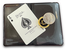 Playing card with Bicycle logo and an Ace of Spades, placed on a black case with a coin on top.