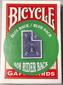 Bicycle playing card deck with blue back and green circle on a gray background