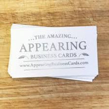 Stack of white business cards with text on a wooden surface