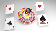 Four playing cards with suits and a colorful circular object in the center on a gray background.