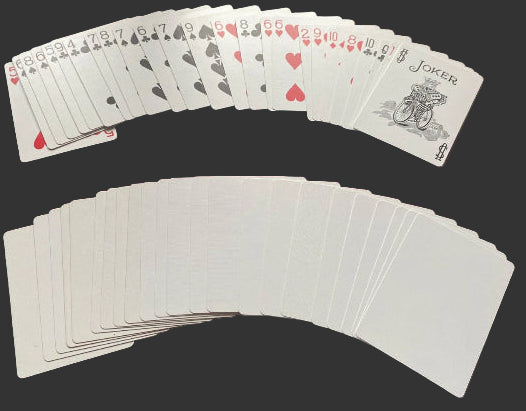 Playing cards fanned out on a red surface with jokers included