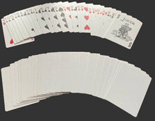 Playing cards fanned out on a red surface with jokers included