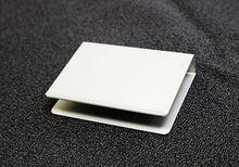 Two white square cards stacked on a textured black surface
