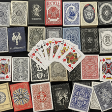 Collection of various playing card decks with a focus on their designs and a spread of cards in the center.