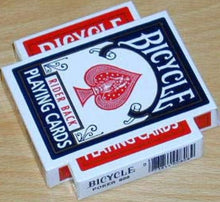 Two decks of Bicycle playing cards on a wooden surface