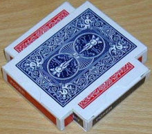 Two decks of playing cards, one red and one blue, stacked on a wooden surface.