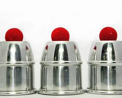 Three metallic cups with red balls on a white background