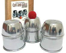 Set of metallic cups with a red ball, branded 'Cups and Balls', on a white background.