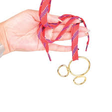 Hand holding a keychain with a red ribbon against a white background