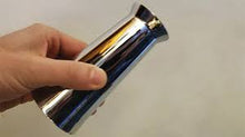 Hand holding a chrome cylindrical object against a plain background