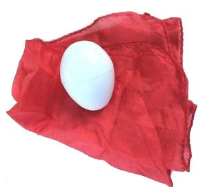 White egg on a red fabric background