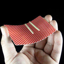 Hand holding a red and white checkered card with two yellow bands on a black background