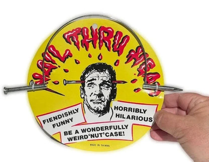 Circular product with a face illustration and text, held by a hand on a white background