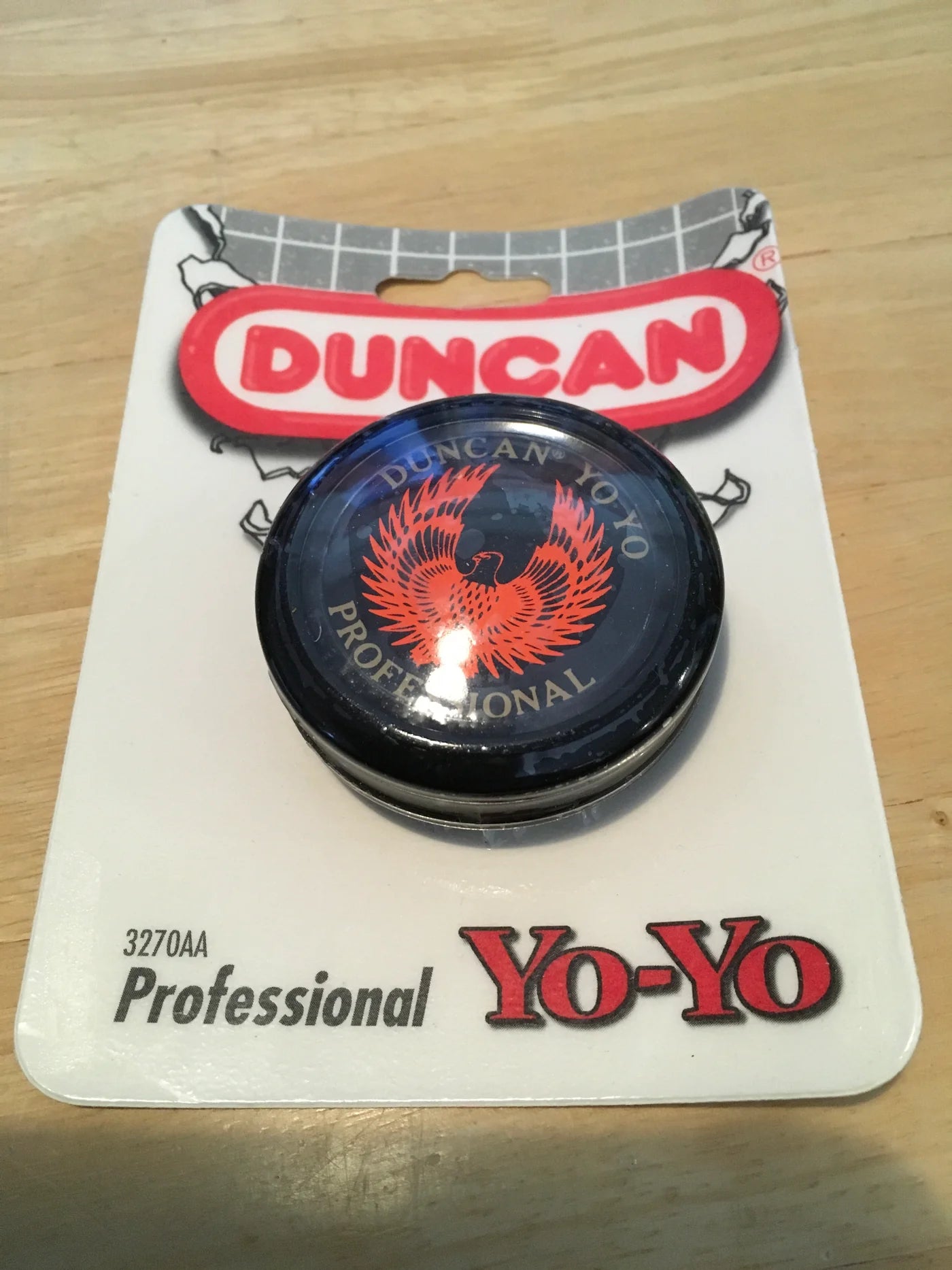 Duncan yo-yo on a branded card with a wooden surface background