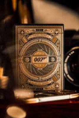 Gold playing card box with '007' branding on a blurred background