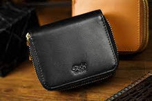Black leather wallet with a brand logo on a wooden surface