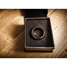 Bronze ring in a box on a wooden surface