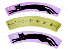 Three curved paper strips with black cat illustrations on a white background