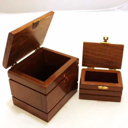 Two wooden jewelry boxes with hinged lids on a white background