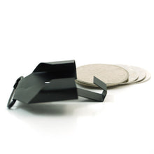 Black geometric object and round beige coasters on a white background